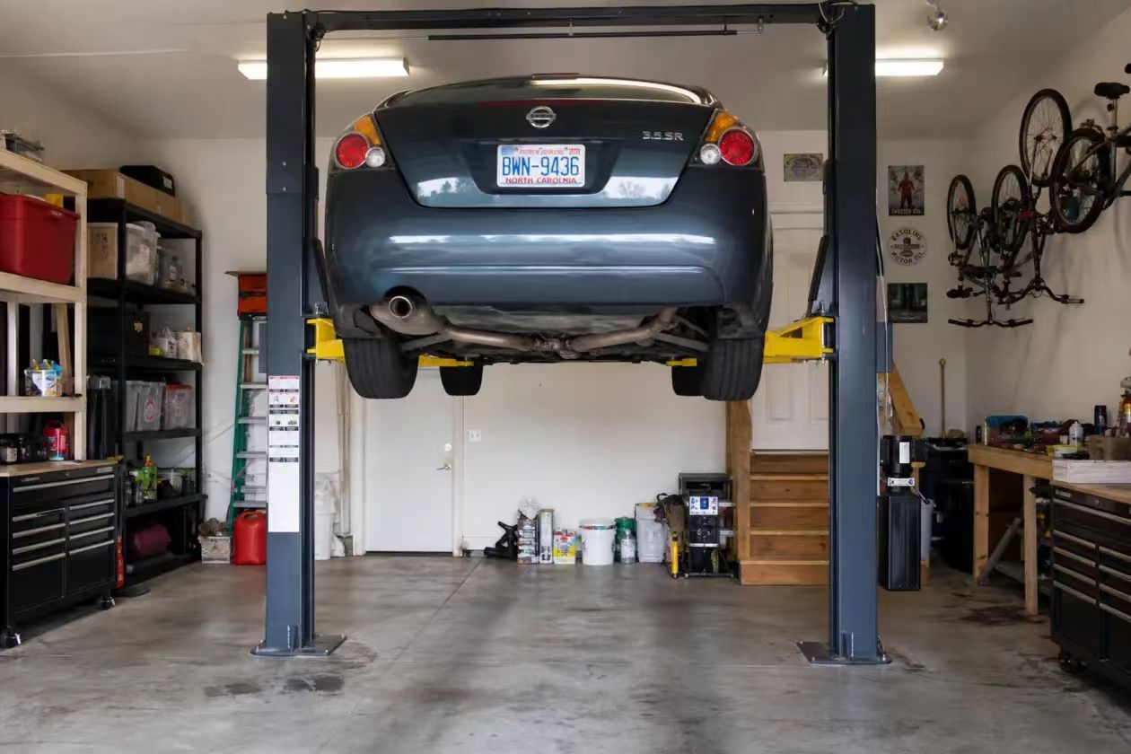 Garage with high-lift door conversion and floorplate car lift installed under a low ceiling