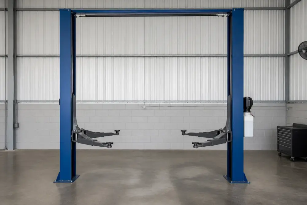 Empty 2 post lift raised during a no-load test cycle with safety locks engaged